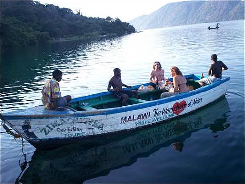 말라위 호수에서 "아프리카의 따뜻한 마음"이란 말라위 관광구호가 적힌 카누를 타고 있는 외국 여행객