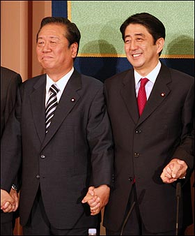 오자와 이치로 민주당 당수(왼쪽)가 지난 7월 11일 도쿄에서 당수 정책토론회 뒤 아베 신조 총리와 손을 맞잡고 있다.