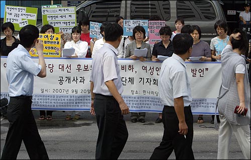  20일 오전 여의도 한나라당사앞에서 열린 이명박 후보의 반복적인 '여성비하발언' 규탄 기자회견장앞으로 직장인들이 지나가며 구경하고 있다.