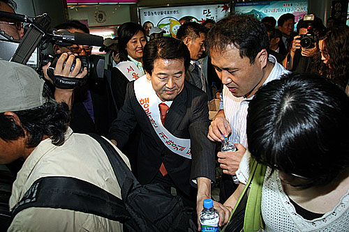 정동영 대통합민주신당 대선 예비후보가 서울역사에서 귀성객들에게 생수를 나누어 주며 '즐겁고 행복한 한가위가 되세요.'라며 인사를 하고 있다.