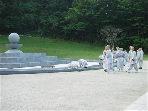  노장스님은 좌정을 하고 다른 스님들은 참배를 한다.