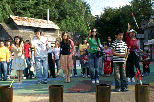 우방타워랜드에 놀러 온 시민들이 투호놀이를 즐기고 있다.