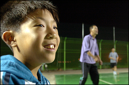 김태수 총무의 아들 김성훈(11) 어린이가 수비수인 아버지가 어려운 공을 받아 올리자 웃어 보이고 있다.