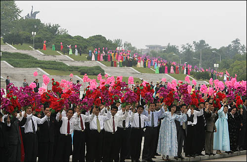 2일 낮 평양시민들이 노무현 대통령과 김영남 최고인민회의 상임위원장이 탄 무개차를 향해 꽃술을 흔들며 열렬히 환영하고 있다.
