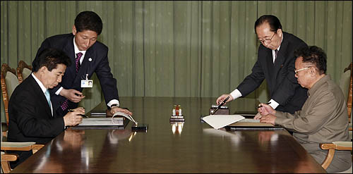 노무현 대통령과 김정일 국방위원장이 4일 평양 백화원 영빈관에서  남북공동선언문에 서명하고 있다.