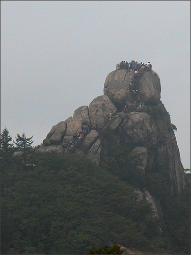  문장대(1054m)를 오르는 사람들. 한참 떨어진 청법대에서 찍은 것이다.  