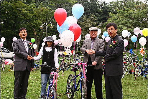 지역사회 아동과 노인에게 재활용된 자전거를 전달하는 이종두 용산구 주민생활지원국장(맨좌측)과 임영인 성공회 다시서기센터 소장(맨우측)