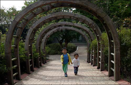 장미원의 장미 터널을 병찬과 명옥이 지나고 있다.
