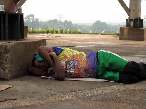 사탕수수 노동자의 오침. 한 사탕수수 에탄올공장 노동자가 공장 내부 그늘을 찾아 낮잠을 자고 있다.