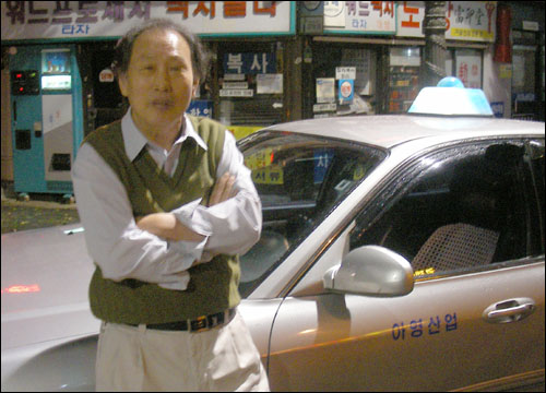 포즈를 취해달라고 부탁하니, 자신의 택시에 기대어 서있는 이창우씨.