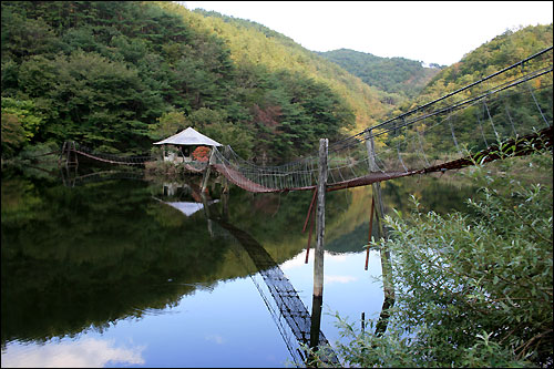 저수지 한가운데 정자로 이어지는 출렁다리는 한 폭의 아름다운 수채화다. 물빛에 비친 그림자가 차라리 더 아름답다. 

 

