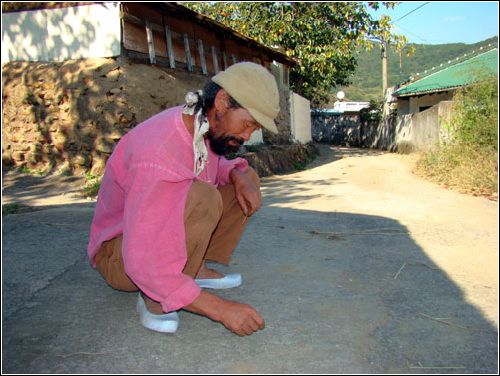 노자영 씨가 땅바닥에 글을 써가며 피해에 대해 설명하고 있다.