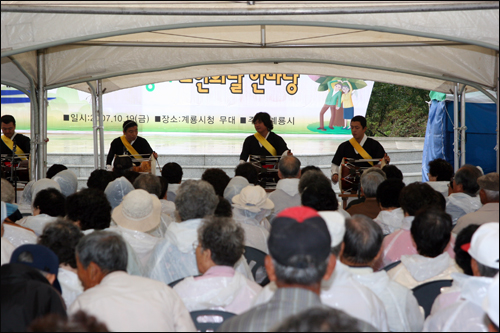 비가와도 즐거워요 갑자기 비가내리는 관계로 행사장인 새터산공원에는 급하게 천막이 설치되었다. 천막 안에서 공연을 지켜보는 노인들의 모습.