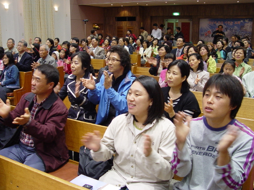 행사에 참석한 관객들이 김석균씨의 찬양에 맞춰 함께 노래하고 있다.