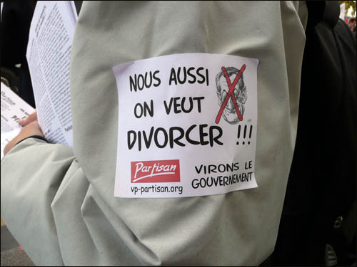 한 시위 참가자가 "우리도 이혼하고 싶다"라는 글귀가 적힌 전단을 달고 있다.