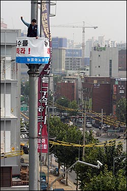 지난 2007년 10월23일 뉴코아노조 박명수씨가 서울 신촌 이랜드 본사 앞 50여m 높이의 교통관제탑에서 '이랜드그룹 박성수 회장 구속'을 촉구하며 고공농성을 벌이고 있다.