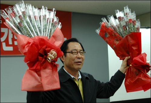 권영길 후보가 5일 저녁 민주노총 경남본부 강당에서 열린 전현직 노동조합 간부 간담회에 앞서 선물로 받은 꽃다발을 들어 인사하고 있다.
