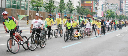 자전거도시 만들기 캠페인에 참여한 참가자들이 두산위브 아파트를 지나고 있다.