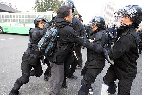  11일 오후 서울시청앞 광장에서 '한미FTA 저지, 비정규직 철폐, 반전평화를 위한 2007범국민행동'이 열릴 예정인 가운데 원천봉쇄에 들어간 경찰들이 도로에 나와 있는 시민들을 연행하고 있다.