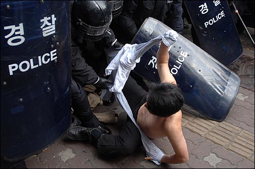 11일 오후 서울시청 부근에서 열린 '한미FTA 저지, 비정규직 철폐, 반전평화를 위한 2007범국민행동'에서 한 시위 참가자가 옷이 찢겨 진 채 경찰에 연행되고 있다. 