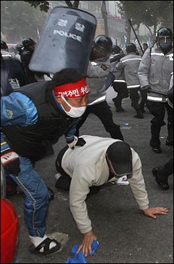 11일 오후 광화문우체국 부근에서 '한미FTA 저지, 비정규직 철폐, 반전평화를 위한 2007범국민행동'에 참석했던 노동자들을 경찰이 방패로 공격하고 있다.