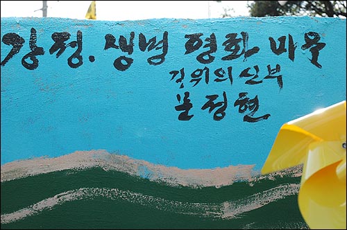 문 신부가 제주도 강정마을 평화벽화 한 귀퉁이에 서명을 남겼다.