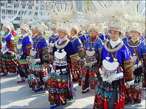 화려한 은장식 화관을 쓰고 다채로운 성좡을 차려입은 젊은 묘족 여성들. 레이산 여성들은 먀오녠 축제기간 동안 누구나 여왕이 되어 자신의 아름다움을 뽐낸다.