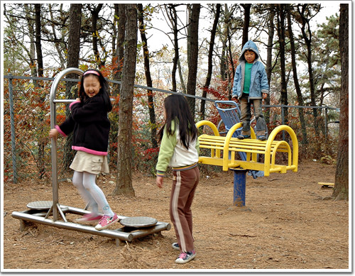 산에 설치되어 있는 운동기구에서 즐겁게 노는 아이들