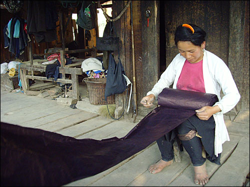 주택 바깥에서 말린 동족 전통의복인 '민감'의 옷감을 거두는 한 여인. 지금도 전통제조방식 그대로 만들어지는 민감은 방수·방풍이 뛰어나고 색감도 아름답