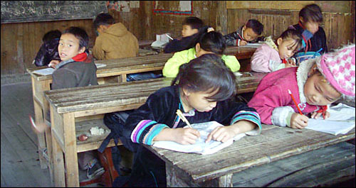퇴락한 교실 안 낡은 걸상에 앉아 아침자습에 열중인 잔리초등학교 2학년 어린이들.