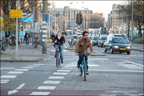 자전거 신호등이 주어지자 자전거 전용 횡단보도를 이용해 교차로를 건너고 있다. 화살표는 자전거전용도로를 알려주는 표시다.