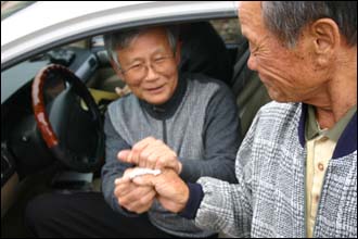 기노식씨(오른쪽)가 어머니의 친정 손자 고영준 선생에게 노잣돈을 전하고 있다.