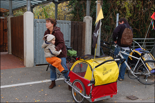 독일의 많은 주부들은 자전거를 쇼핑뿐 아니라 유아용 유모차를 연결해 이용하고 있다. 한 주부가 자전거에 연결된 유모차에서 아이를 내리고 있다.  
