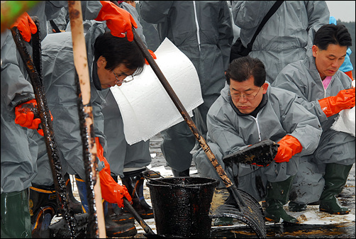 태안 만리포 해안에서 기름 제거작업을 벌이고 있는 문 후보