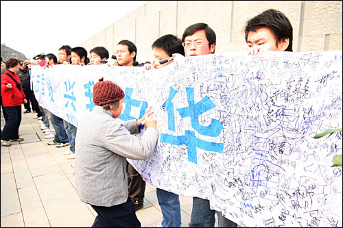 대학살의 역사를 잊지 않겠다는 플래카드에 굳은 다짐의 맹세를 사인하는 난징 시민들.