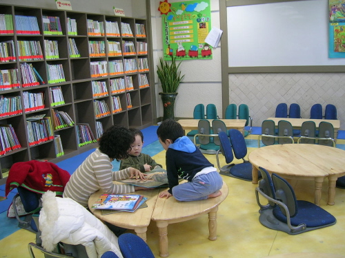 복지관 3층에 있는 도서관에서 책읽어주는 엄마 옆으로 두 아이들이 귀를 쫑긋 세우고 듣고 있다.