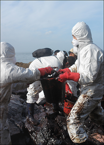 소원면 의항리 해변에서 기름을 나르는 자원 봉사자들 