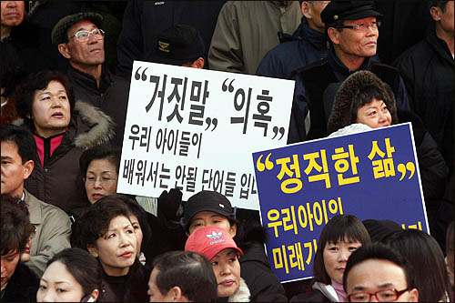 이명박 후보가 BBK를 직접 설립했다고 밝힌 동영상이 공개된 가운데, 정동영 후보 지지자들이 16일 오후 서울 명동 유세에서 이 후보의 사퇴를 촉구하고 있다.