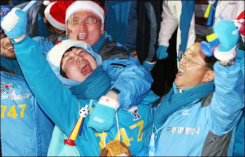제17대 대통령 선거 투표가 완료된 지난해 12월 19일 오후 6시 서울 여의도 한나라당 당사에 모인 이명박 후보 지지자들이 각 방송국의 출구조사 결과를 확인한 뒤 환호하고 있다.
