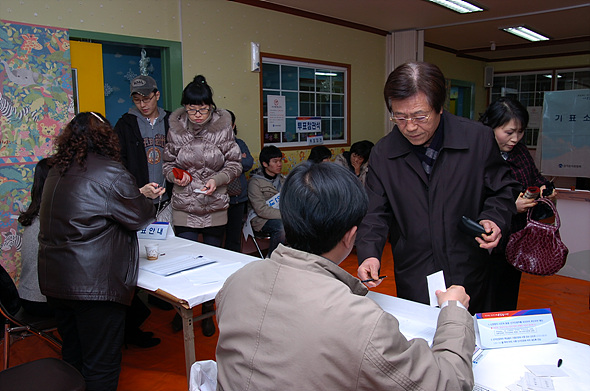 제17대 대통령 선거 투표소에서 주민들이 투표를 하기 위해 투표인 명부를 확인하고 있다.