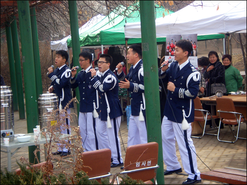 모금현장을 열기로 공군본부 군악대원들이 성금모금이 실시되는 공원에 나와 흥겨운 노래로 분위기를 고조시키고 있다.