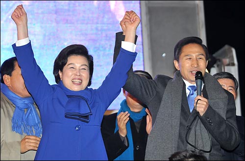 이명박 대통령 당선자가 19일 밤 서울 청계광장에서 열린 지지자들과의 행사에서 부인 김윤옥씨의 손을 들어주고 있다.