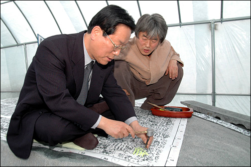박영순 구리시장(왼쪽)이 전홍규 한국 금석문 각자예술 연구원장의 도움으로 시각하고 있다.