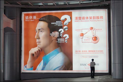홍콩섬 중심에 있는 홍콩상하이은행 본점 1층의 광고판. 퇴직 후 설계에 관한 은행 광고를 한 직장인이 보고 있다.