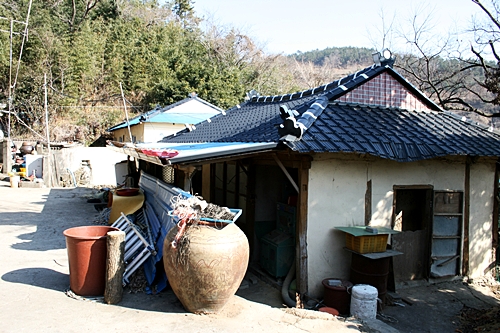 창고로 사용하고 있는 집 지붕에 생선을 말리고 있다.