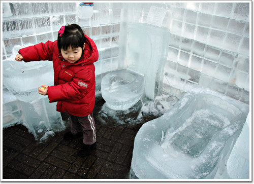  얼음으로 만든 세면대에서 아이가 손을 씻는 표정을 짓는다.