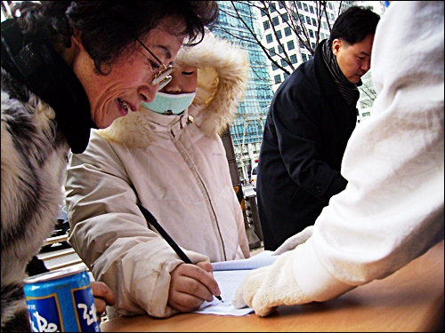 고사리 손도 서명에… 할머니와 같이 나선 어린이가 서명운동에 동참하고 있다.