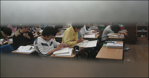 수능등급제 폐지가 결정된 22일 밤, 서울 노량진의 한 재수학원에서 창 틈을 통해 공부하는 학생들의 모습이 보이고 있다.