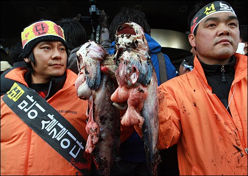 삼성본관앞에서 어민들이 기름에 오염된 물고기를 들고 있다.