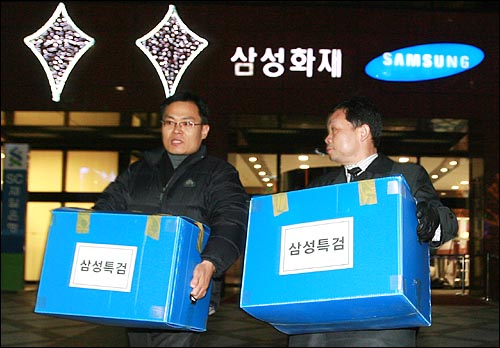 삼성특검 수사관들이 25일 저녁 서울 중구 삼성화재 본사에서 압수한 물품을 상자에 넣어 나오고 있다.